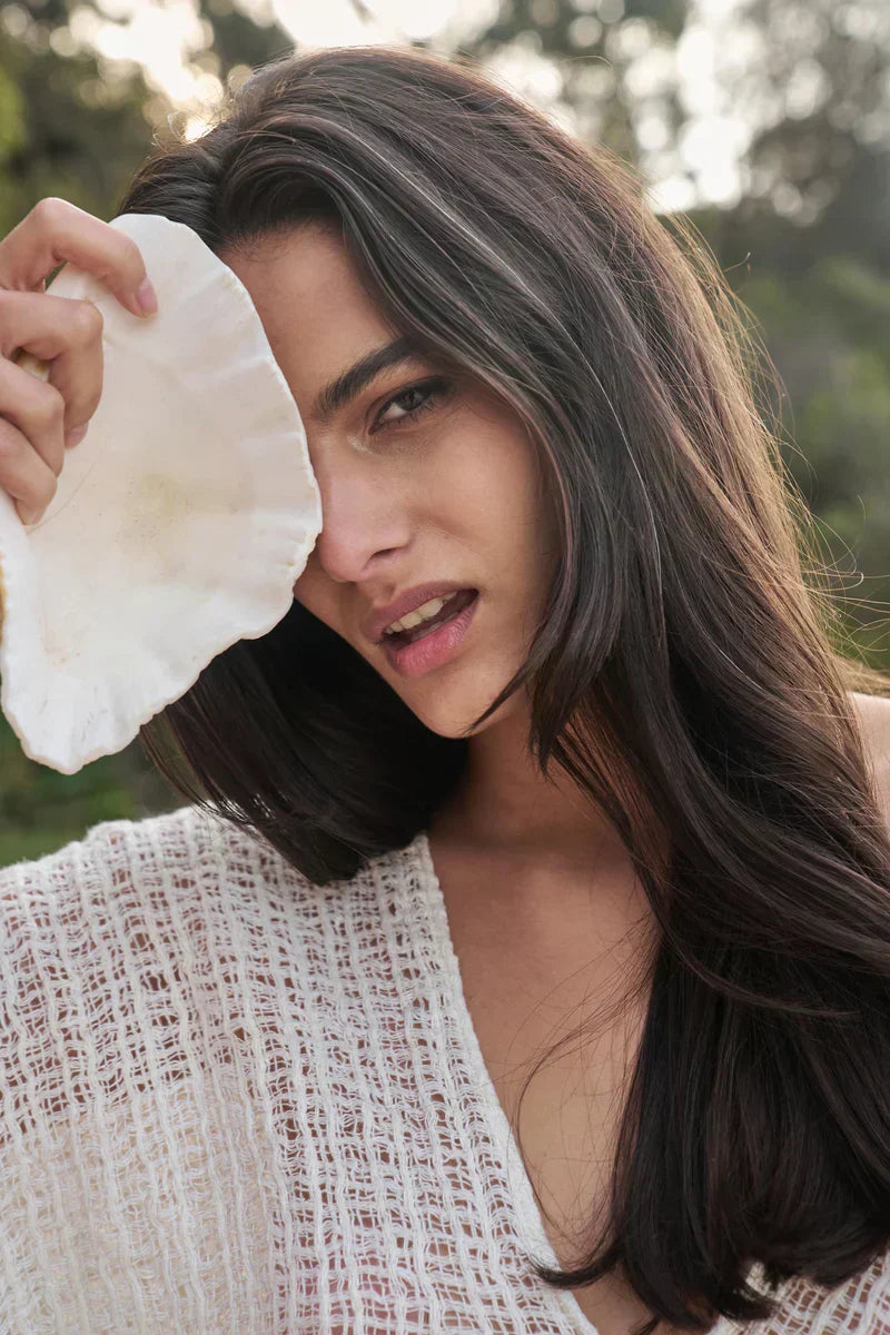 Cestino Weave What we love abaout Estilo Emporio Italian linen weaves. Woman holding shell wearing stunning estilo emporio top