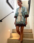 Woman in a patterned dress standing on a staircase
