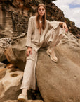 Estilo Emporio Linen Pant Novo Flare - Brasile Natural worn by model in natural setting LUXAMORE