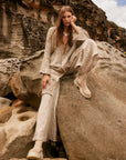 Estilo Emporio Linen Pant Novo Flare - Brasile Natural worn by model in natural setting LUXAMORE