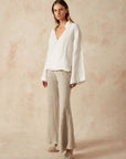 Estilo Emporio Linen Pant Novo Flare - Brasile Natural worn by model in natural setting LUXAMORE