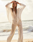Estilo Emporio Linen Pant Novo Flare - Brasile Panna White worn by model in natural setting LUXAMORE