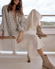 Estilo Emporio Linen Pant Novo Flare - Brasile Panna White worn by model in natural setting LUXAMORE