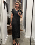 Woman taking a mirror selfie wearing a la bottega di brunella linen dress made in italy in a room.