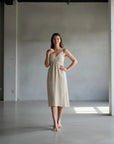 Linen Dress Cross Tie Made in Italy beige worn by model in natural setting LUXAMORE