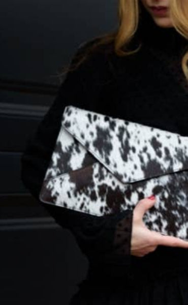 woman clutching cowhide clutch