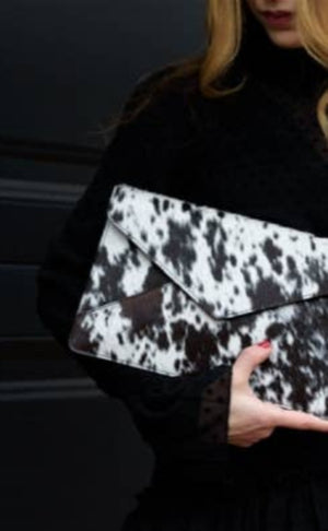 woman clutching cowhide clutch