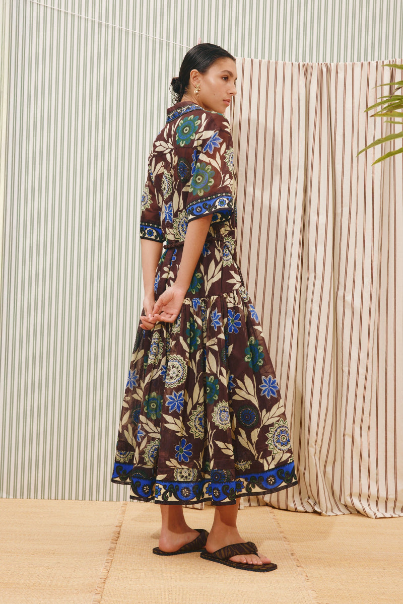 Alemais_Jasper_Shirtdress  Woman wearing a patterned dress standing against a striped curtain.