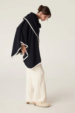 Cable Melbourne Woman wearing the Glenelg Merino Cape in Midnight Navy, a medium-weight wool cape with contrast trim, styled for cool-weather layering.
