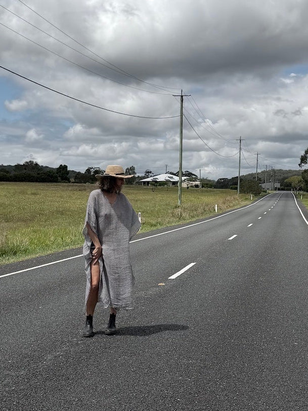 Person walking on a rural road with a cloudy sky