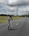 Person walking on a rural road with a cloudy sky