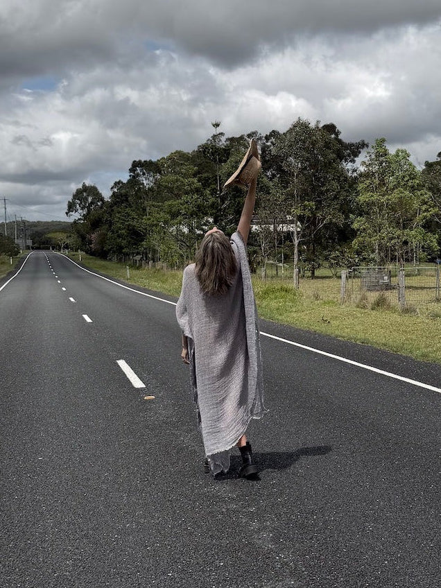 Person in a long estilo emporio maxi dress standing on a road with a cloudy sky