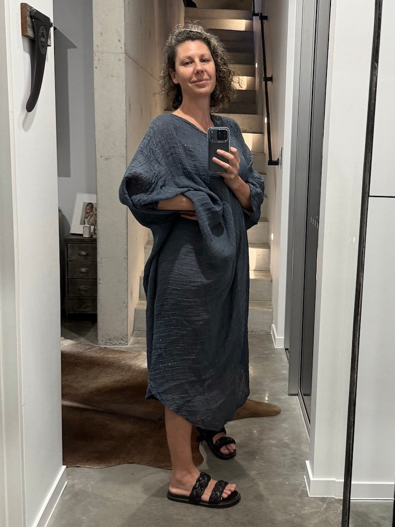 Woman taking a mirror selfie in a modern interior setting with decorative la bottega di brunella linen dress made in italy