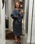 Woman taking a mirror selfie in a modern interior setting with decorative la bottega di brunella linen dress made in italy