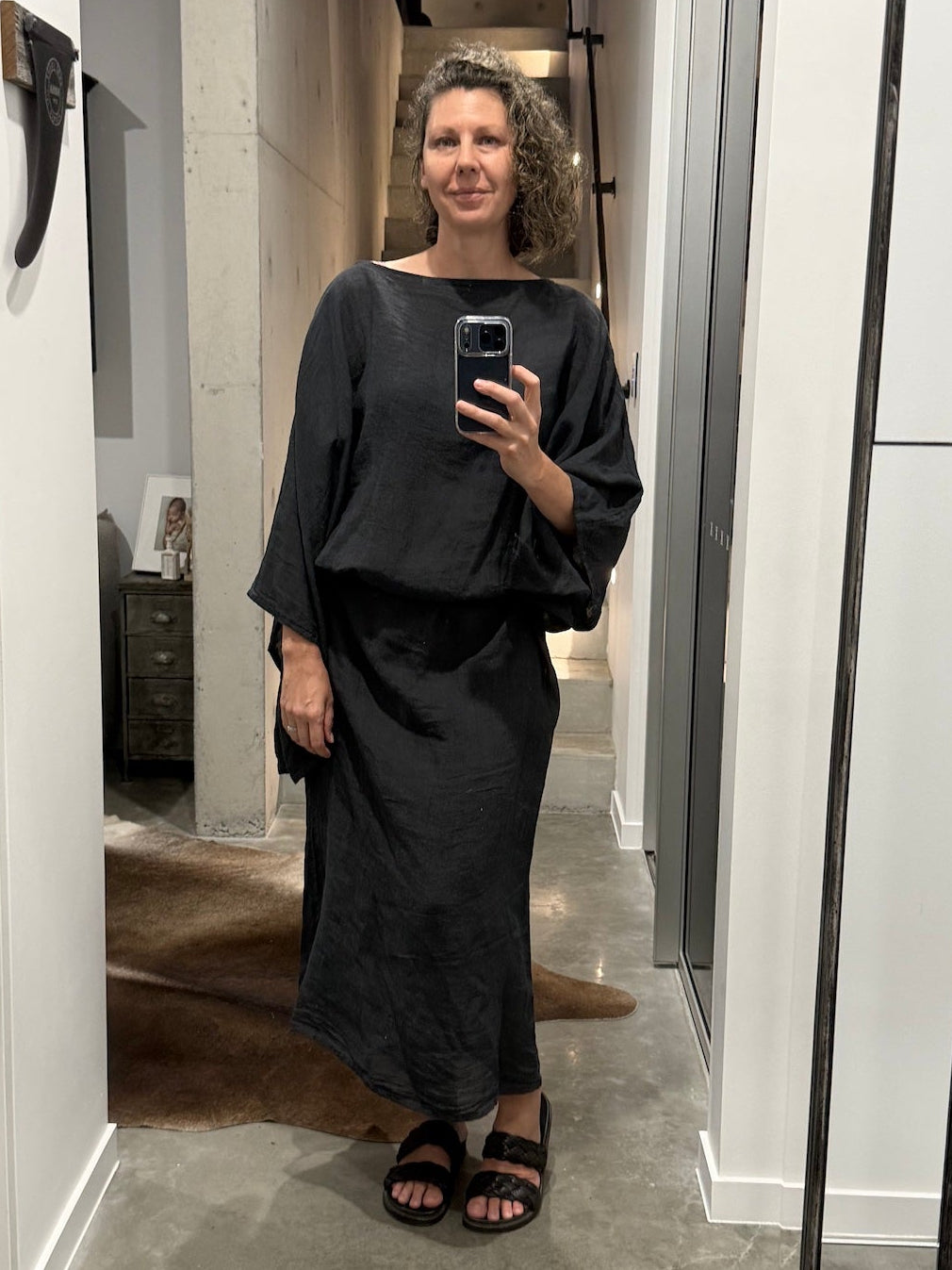 Woman taking a mirror selfie wearing la bottega di brunella linen dress made in italy in a hallway.