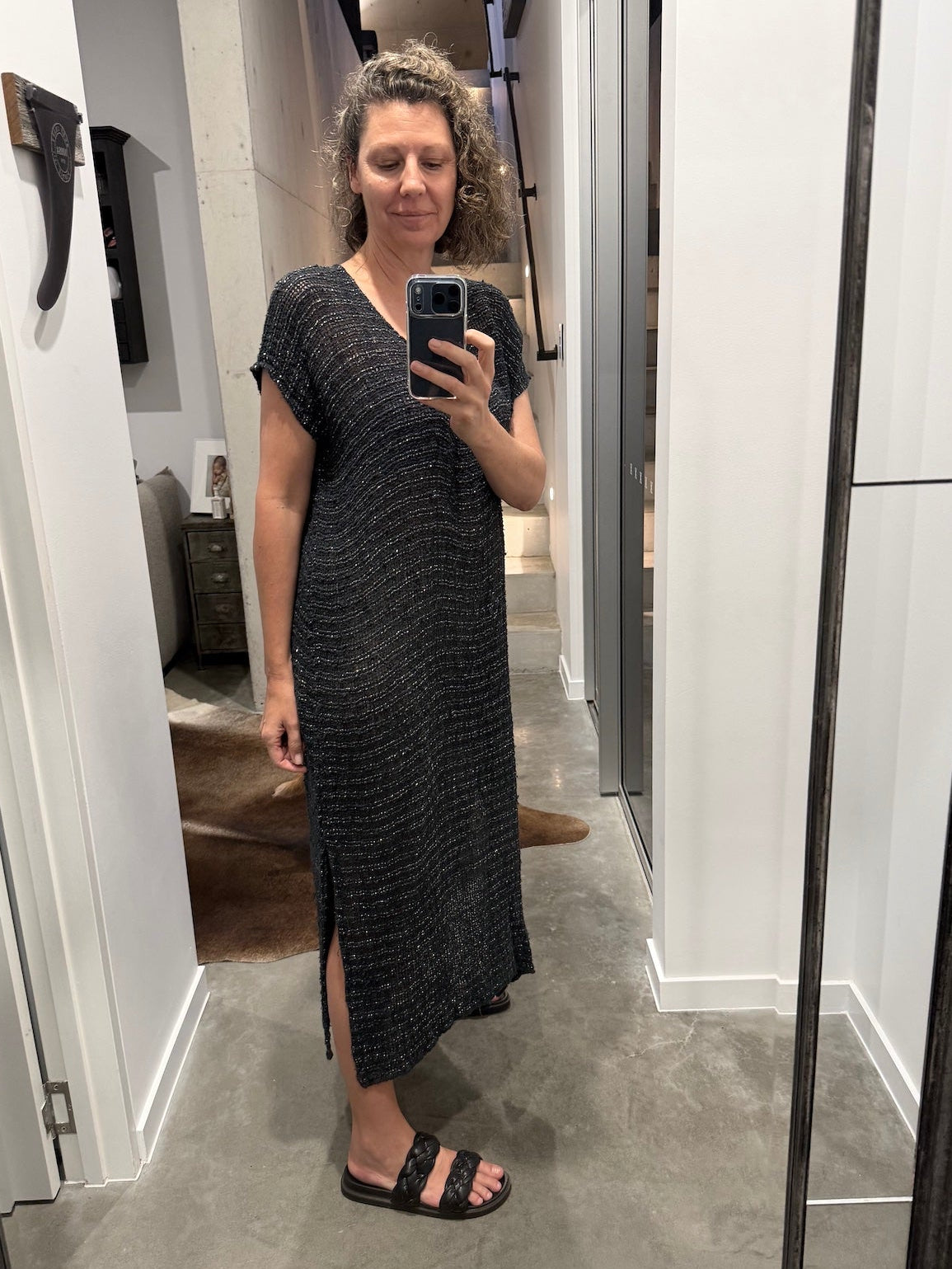 Woman taking a mirror selfie wearing a la bottega di brunella linen dress made in italy in a room.