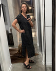 Woman taking a mirror selfie wearing a la bottega di brunella linen dress made in italy in a room with a large mirror.