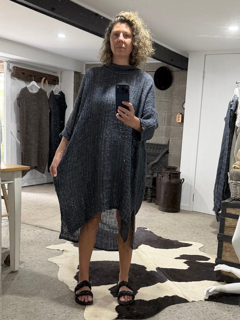 Woman taking a mirror selfie wearing ala bottega di brunella linen dress in a clothing store.