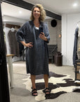 Woman taking a mirror selfie wearing a la bottega di brunella linen dress in a  room with a large mirror.