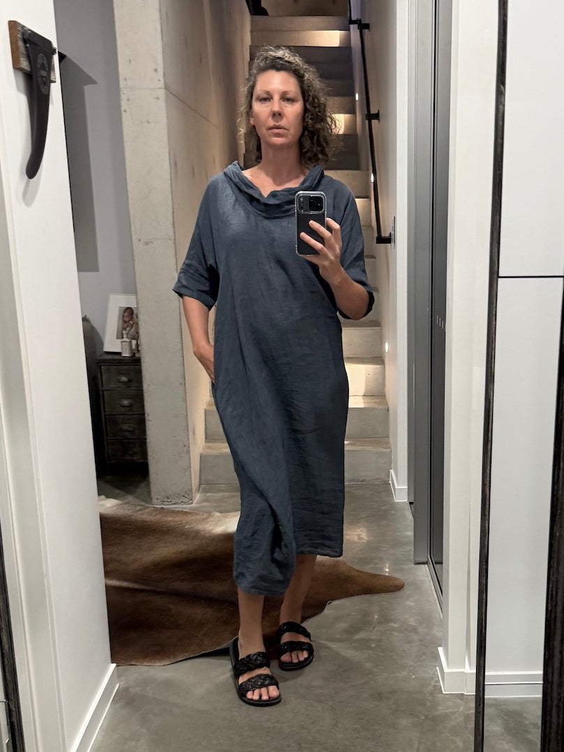 Person taking a mirror selfie in a room with a large floor-to-ceiling mirror wearing la bottega di brunella linen dress made in italy 