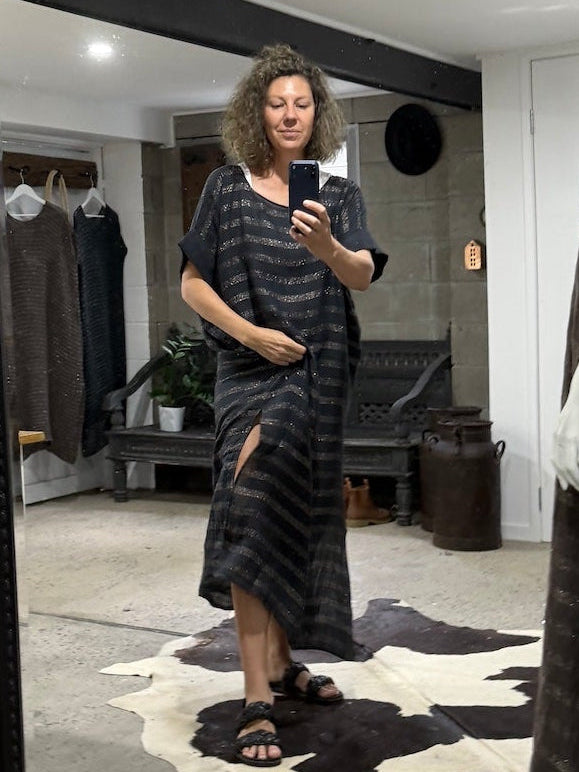 Person taking a mirror selfie wearing a la bottega di Brunella navy linen dress in a room with a large black-framed mirror.