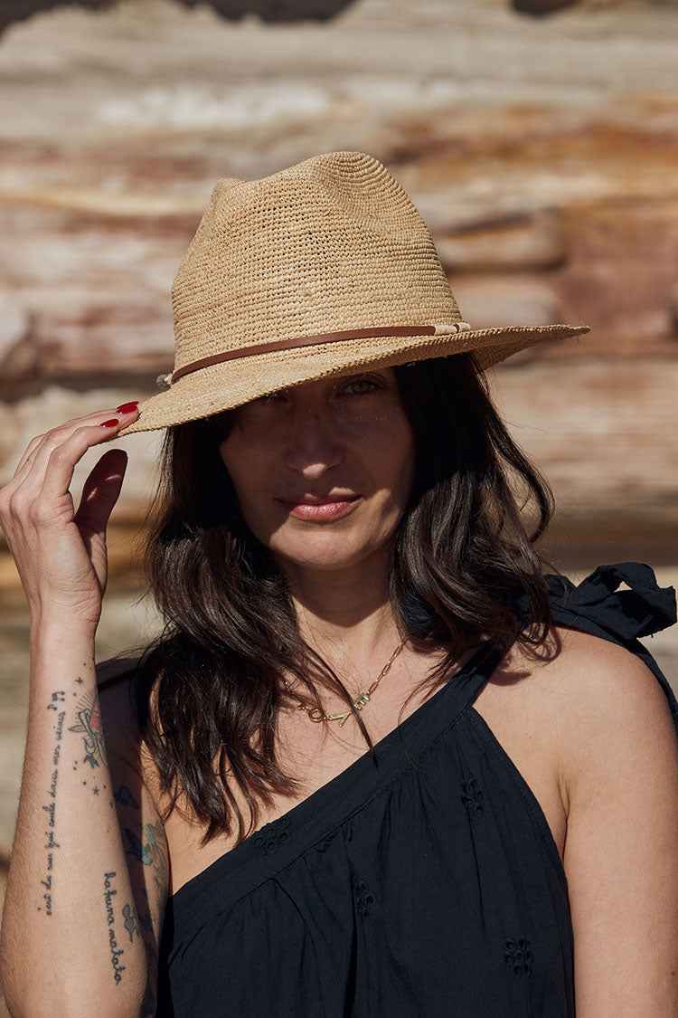 Person wearing Made in Mada Hat ELYA TAN LEATHER linen dress LUXAMORE 